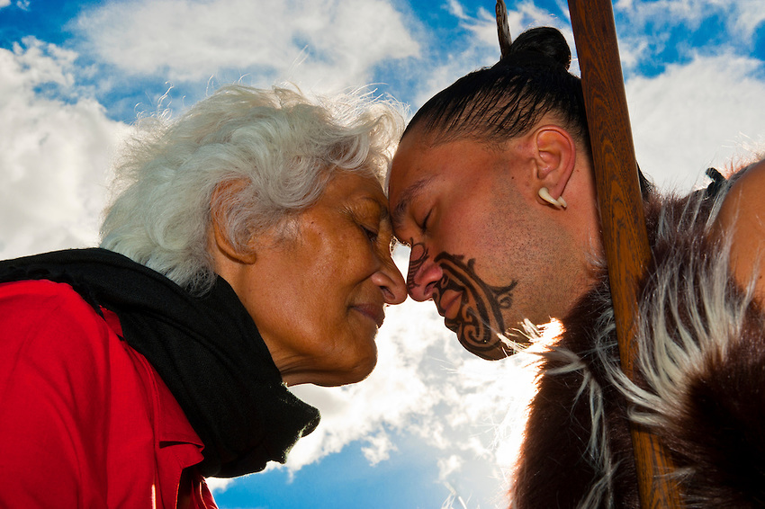 A Maori man with ta moko (facial tattoo) and an elderly Maori woman doing hongi (traditional Maori greeting) , Te Puia (New Zealand Maori Arts & Crafts Institute), Rotorua, New Zealand